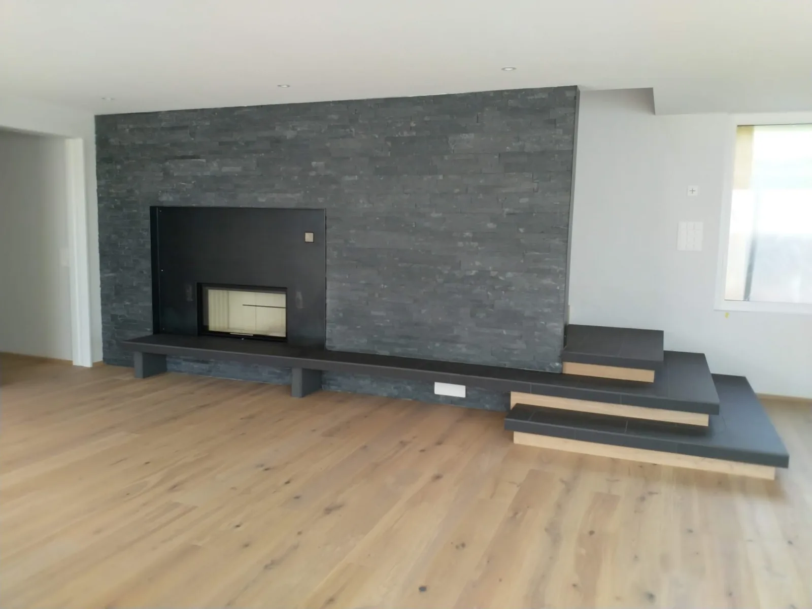 Cheminée mit Schiefer-Steinwand und Stufen