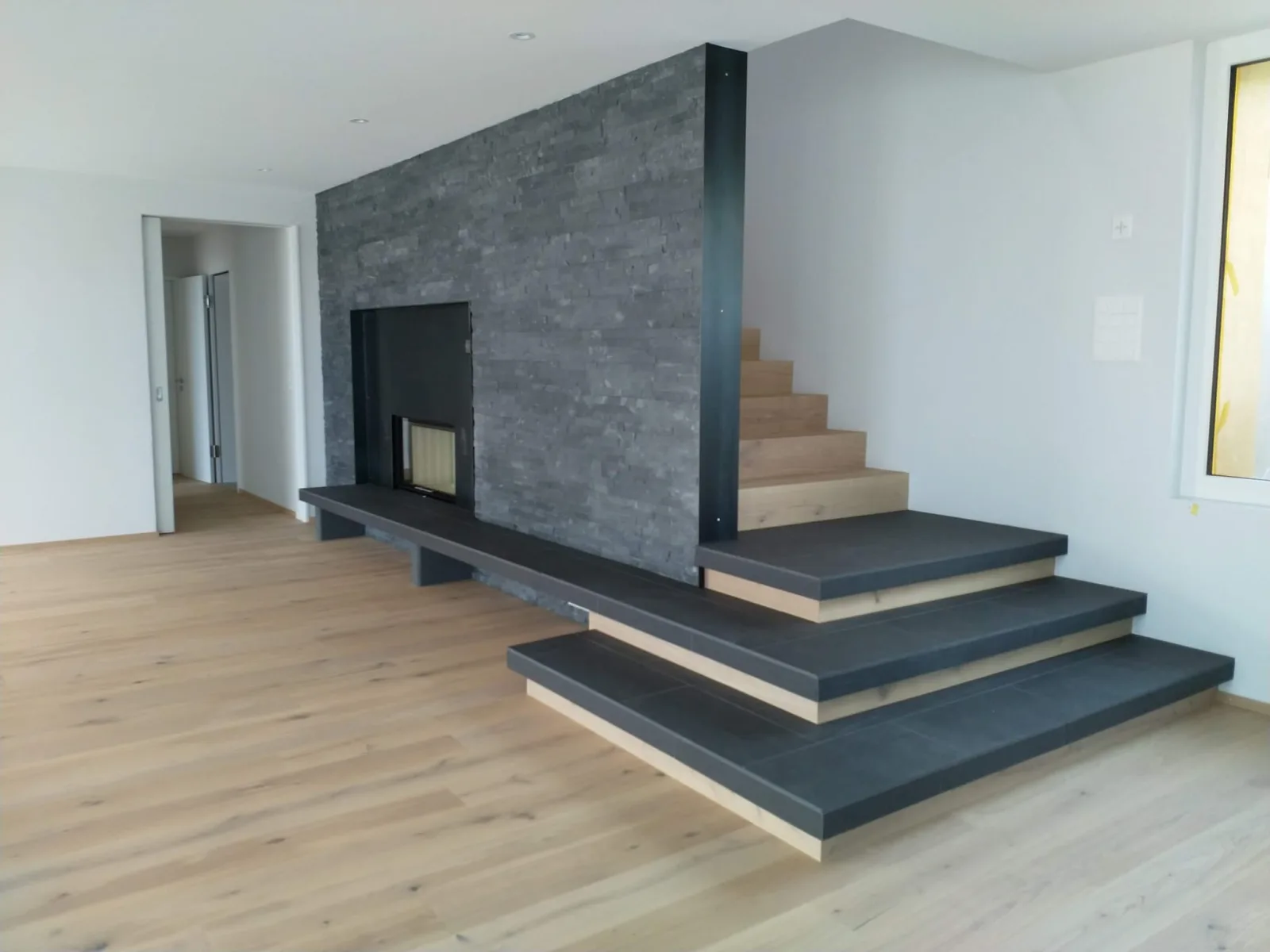 Cheminée mit Schieferwand und integrierter Treppe